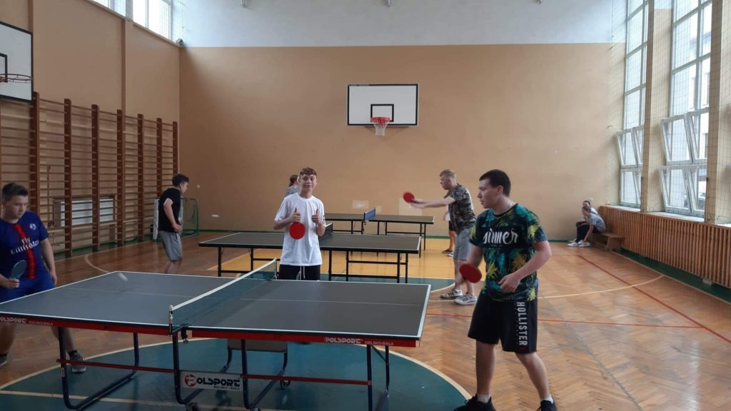 Uczniowie grający w tenis stołowy.