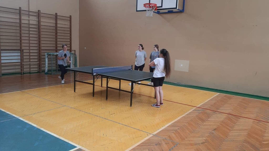 Uczniowie grający w tenis stołowy.