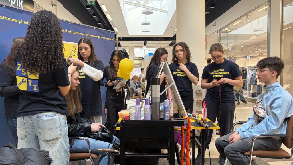 Fryzjerki czeszą chętnych uczestników targów edukacji