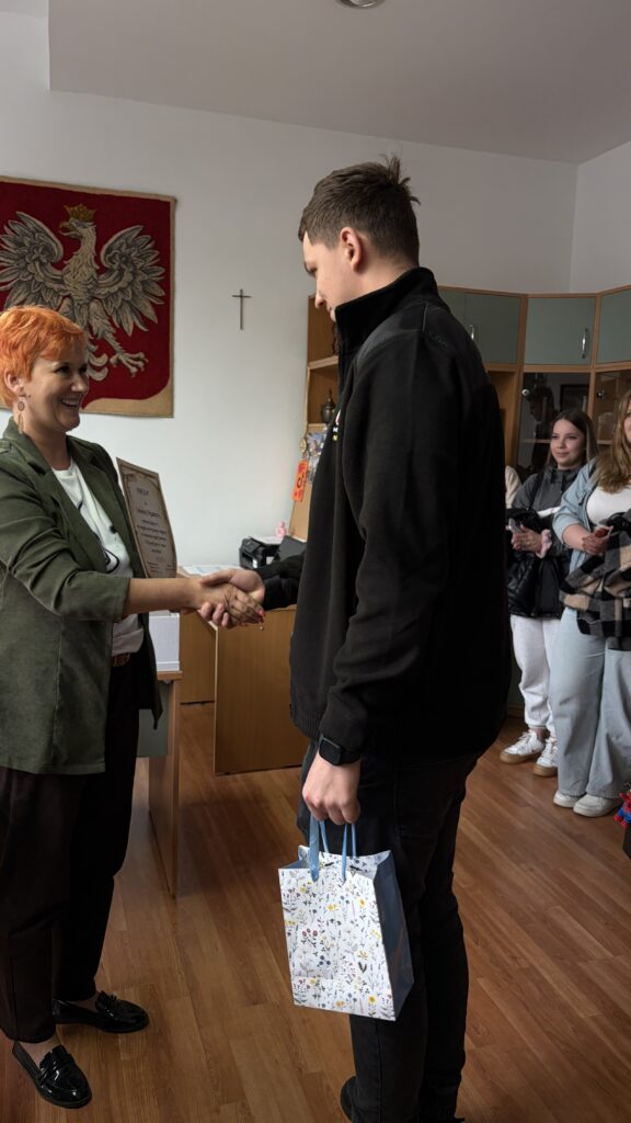 Uczeń odbierający nagrodę od pani dyrektor
