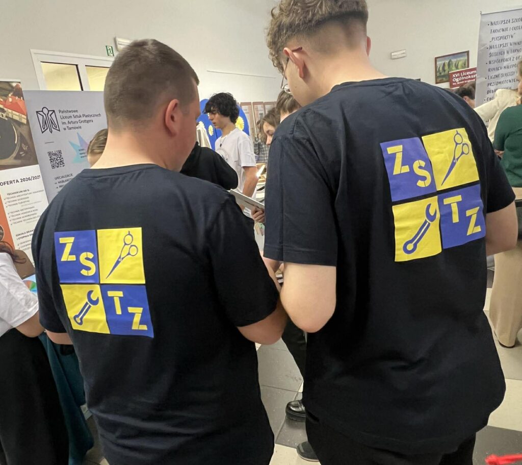 Uczniowie na targach edukacyjnych w koszulkach z logiem ZSTZ