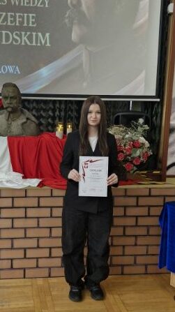 uczennica z dyplomem konkursu wiedzy o józefie Piłsudskim