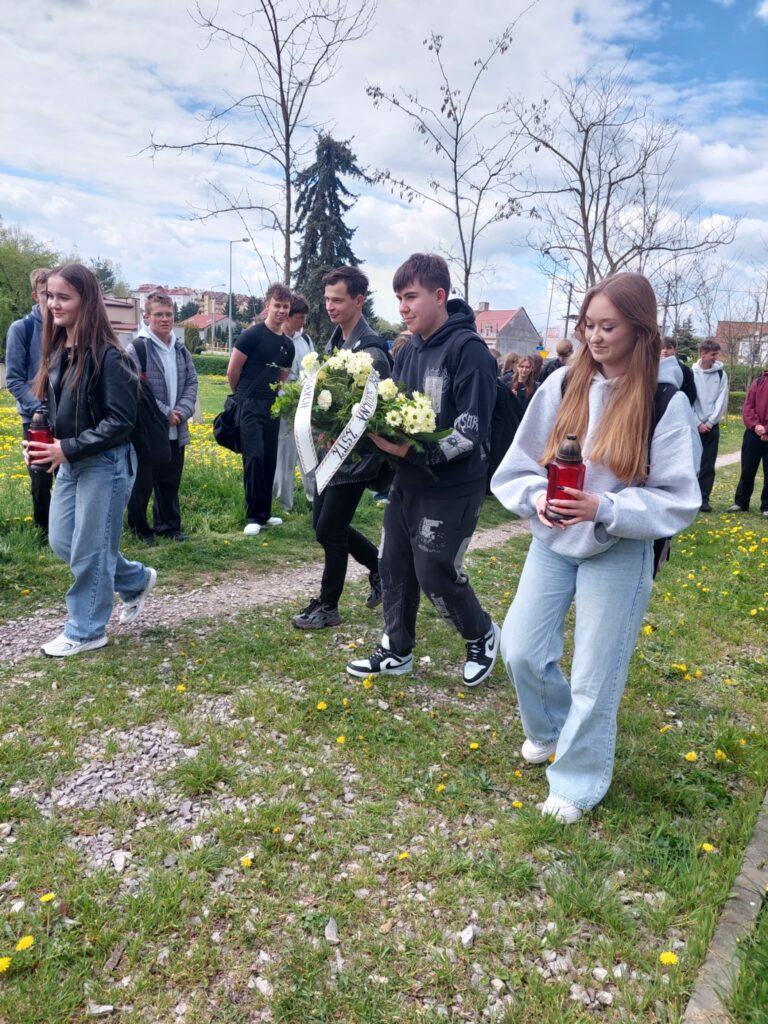 Delegacja wycieczki składa wieniec i znicze na grobie poległych