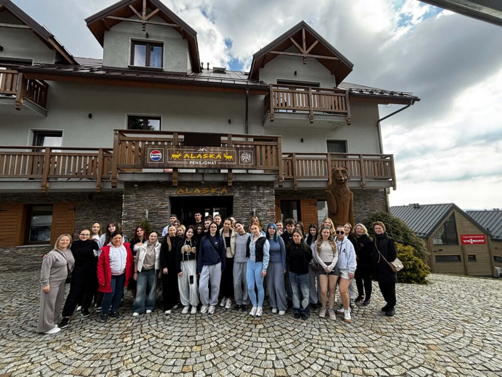 uczniowie i nauczyciele stojący przed pensjonatem Alaska w Zieleńcu